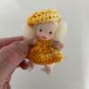 Muñeca pequeña con vestido amarillo hecha a mano por Evaninas.