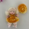 Muñeca pequeña con coletas y vestido amarillo hecha a mano por Evaninas.