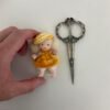Muñeca pequeña con boina amarilla hecha a mano por Evaninas.