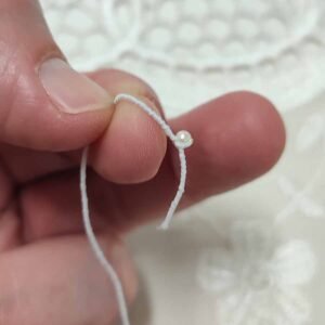 Muestra de hilo elástico con bolita para unir piezas de la muñeca por Evaninas.