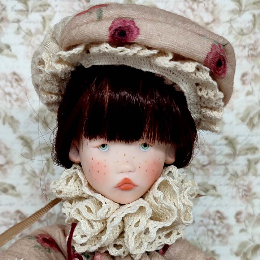 Cara de muñeca con flequillo oscuro hecha a mano por Evaninas.